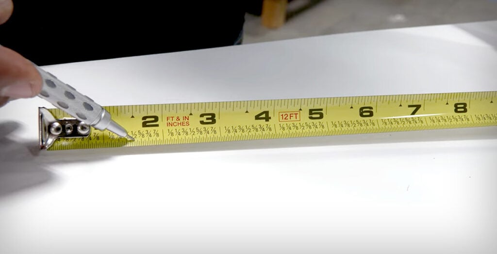 Pointing out 1/2 inch mark on retractable tape measure.